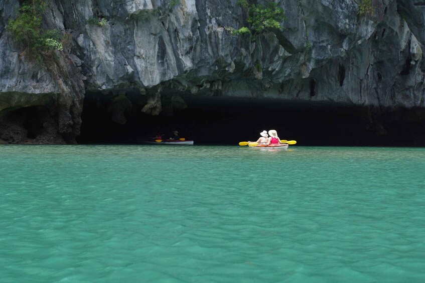 A kayaker in a cove with a rocky cave backdrop. 2