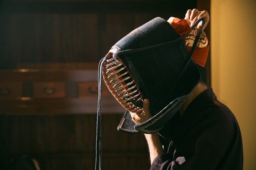 Une personne portant un chapeau noir au design original, qu’elle tient d’une main. 5