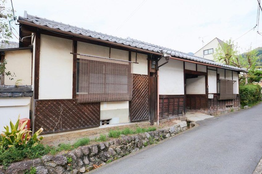 Une maison traditionnelle japonaise avec un toit en tuiles, des poutres en bois et un mur en pierre. 2