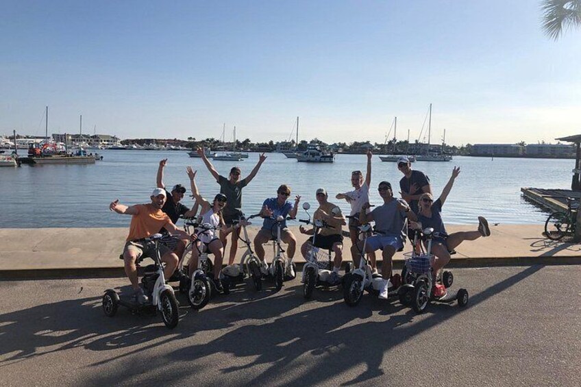 A group of people riding Segways along a waterfront promenade. 2
