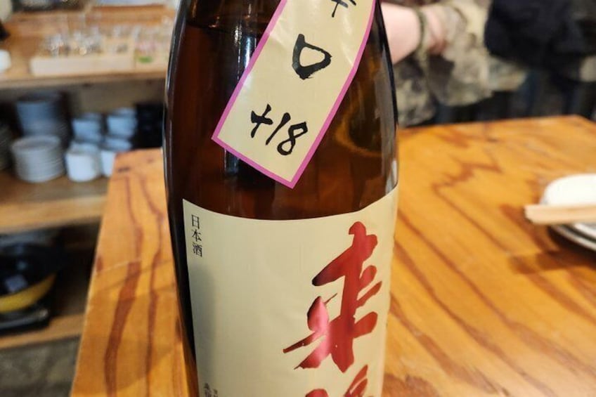A bottle with a price tag of 18 yen on a wooden table. 4