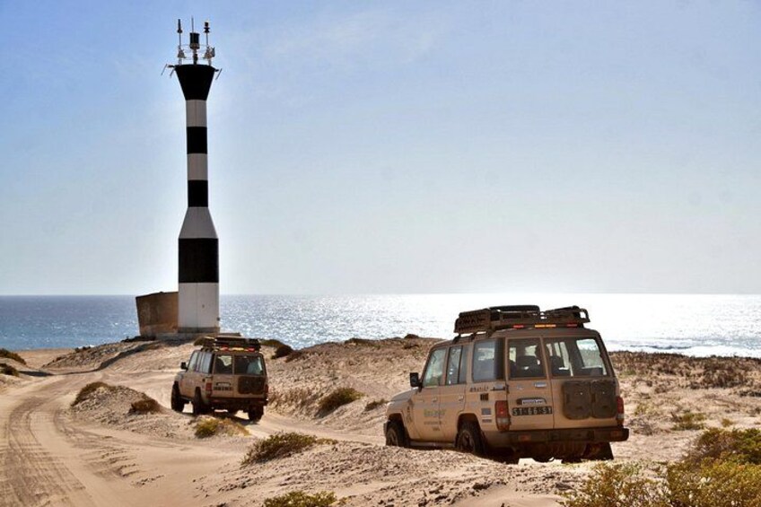 A lighthouse, a jeep, and a desert landscape. 4