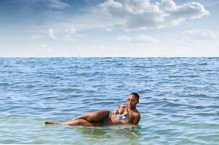 A person lying on a beach with the ocean in the background. 2