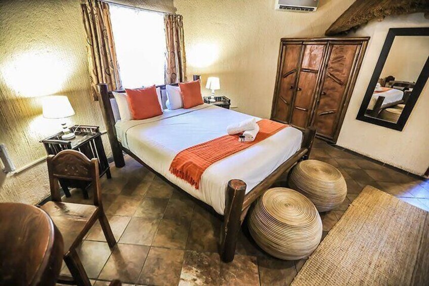 A bedroom with a large bed, wooden furniture, and a mirror on the wall. 4