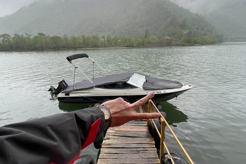 Eine Person am Steg, die sich nach einem Boot auf dem Wasser streckt. 4