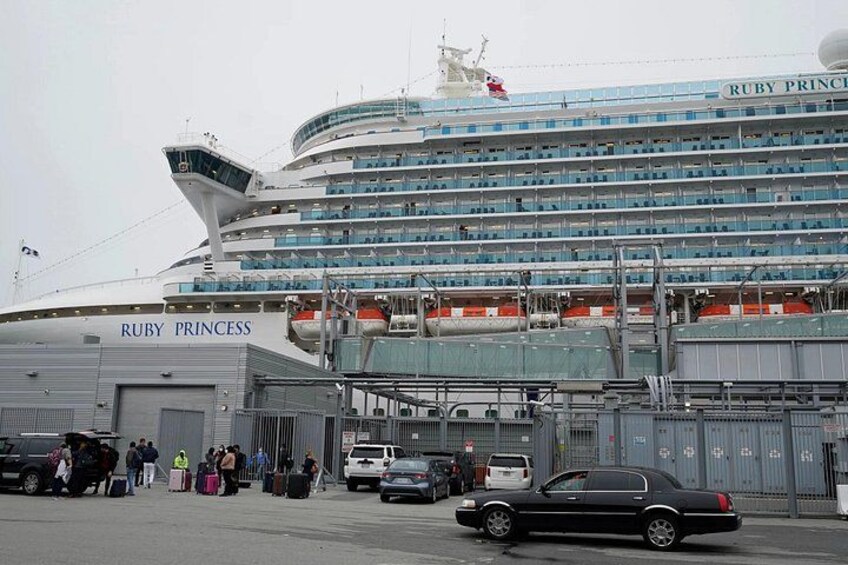 Crucero llamado Ruby Princess amarrado en un puerto con gente y vehículos cerca. 5