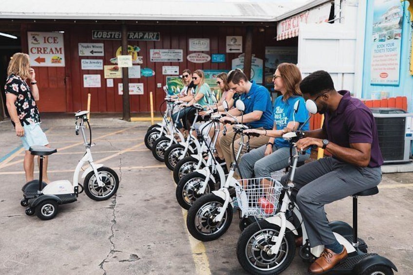 People riding electric scooters in a parking lot with a storefront in the background. 4