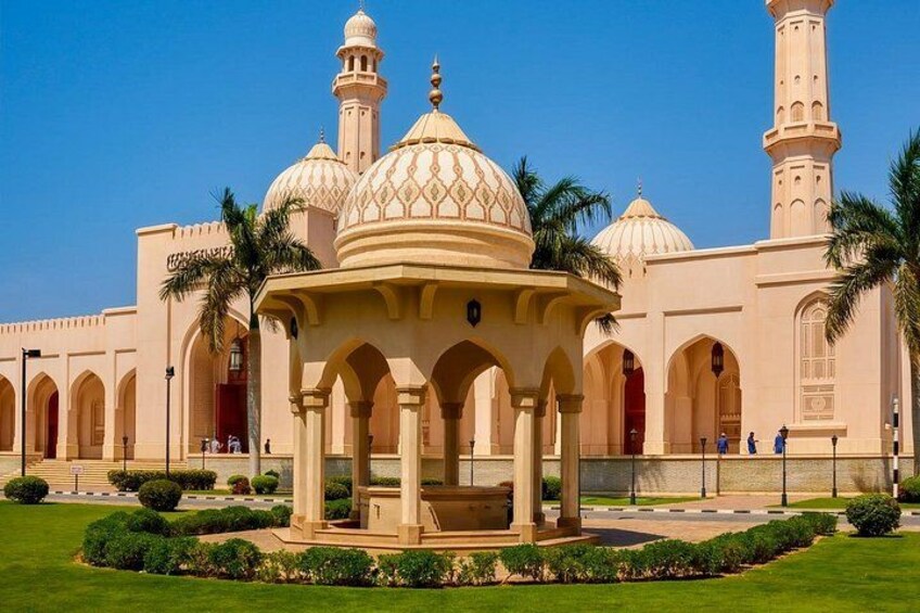 Una moschea con cupole e minareti, circondata da un giardino curato. 5