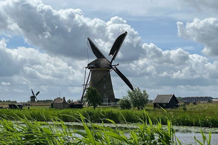 A windmill, a river, and a cloudy sky. 1