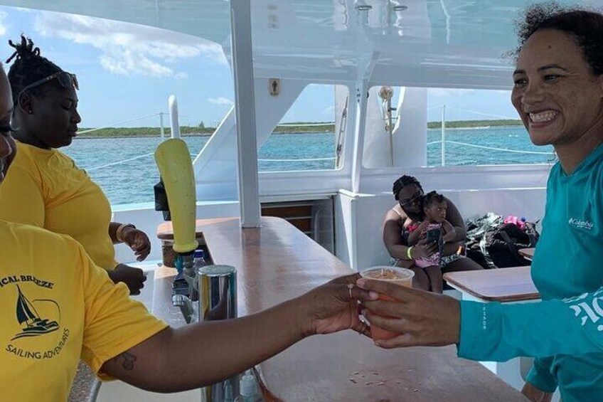 People on a boat, one wearing a yellow shirt with a logo, another in a blue shirt, and a child in the background. 1