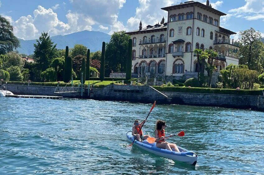 A couple in a small boat on a calm lake, with a large, ornate building in the background. 4