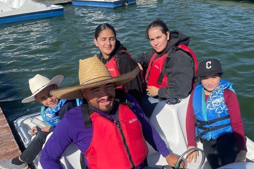A group of people on a boat, wearing life jackets and a straw hat. 4