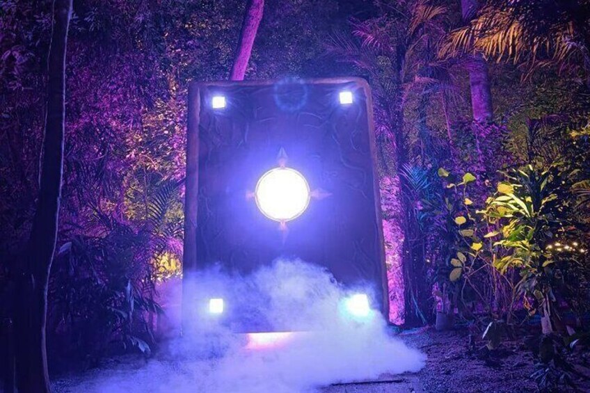 A glowing structure with a circular light in the center, surrounded by mist and surrounded by dense foliage. 3