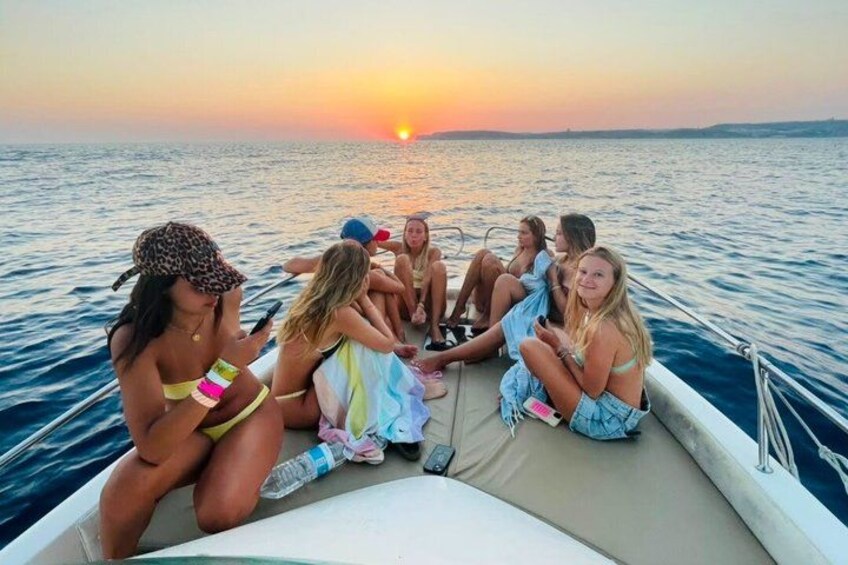 A group of people on a boat at sunset. 4