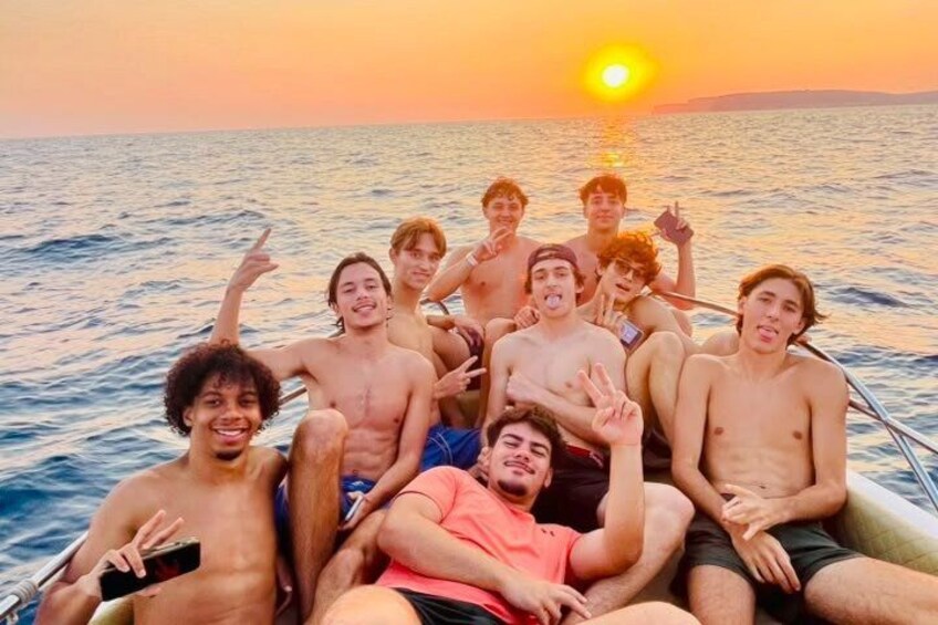 A group of people on a boat at sunset. 3