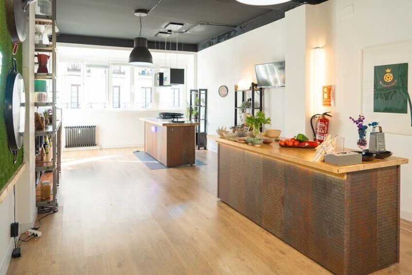 Une cuisine moderne avec des plans de travail en bois, un îlot central et un luminaire suspendu. 5