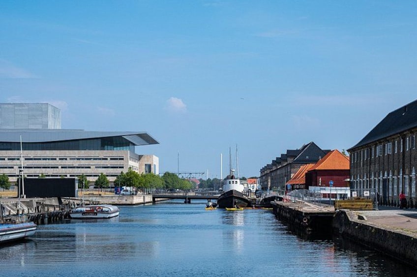 Un canal con barcos, un edificio moderno y arquitectura tradicional. 3
