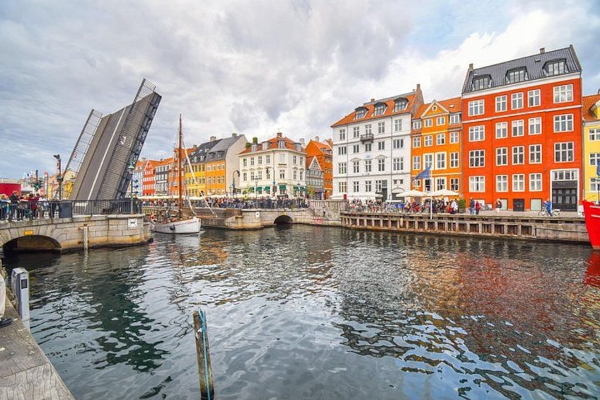 Un canal con edificios, un puente y un velero. 2