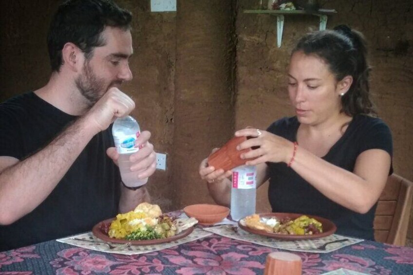 Deux personnes sont assises à une table devant des assiettes remplies de nourriture et une bouteille d’eau. 3