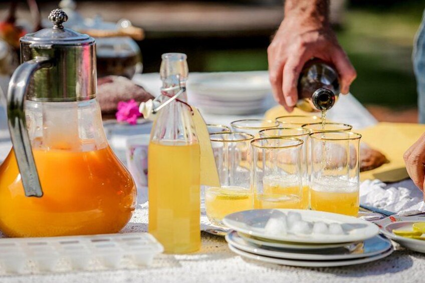 Een karaf sinaasappelsap, een fles citroenlimonade en glazen op een tafel. 2