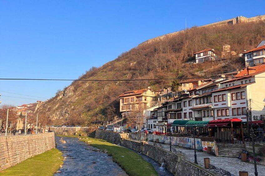 Un río, edificios y una colina con una fortificación. 3