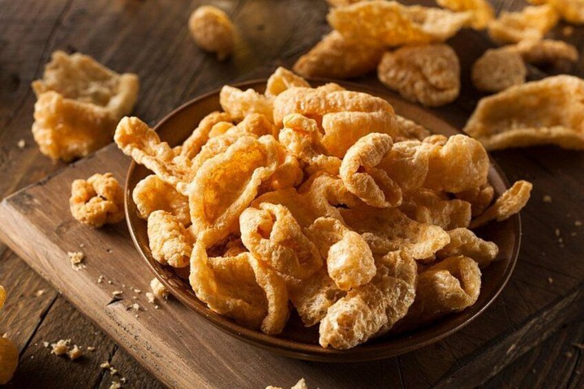 Una ciotola di snack fritti dorati su un piano di legno. 3