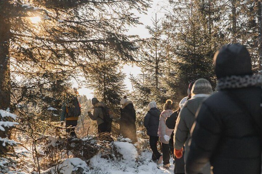 A group of people hiking in a snowy forest. 4