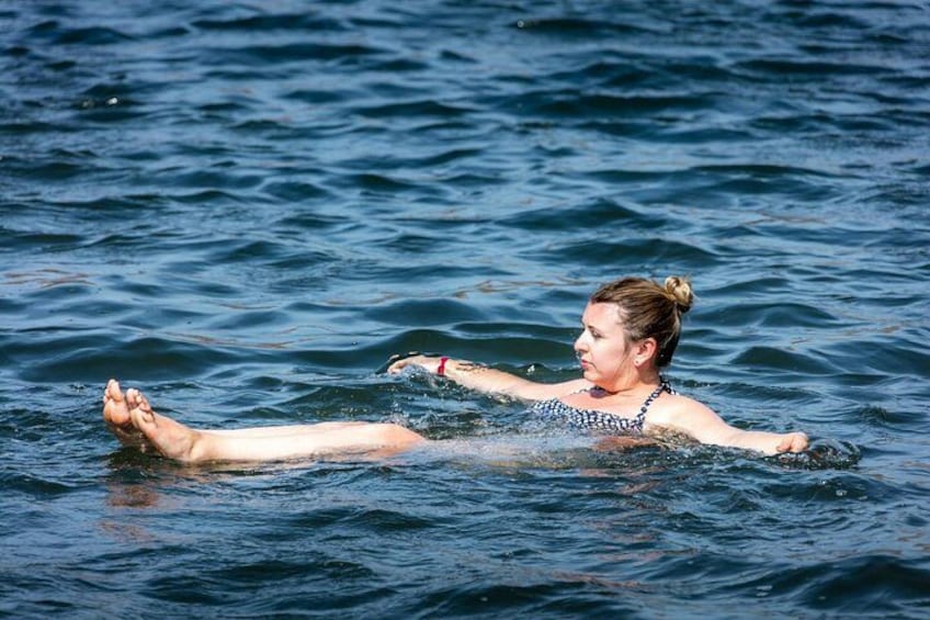 A person floating on water wearing a swim cap and goggles. 4