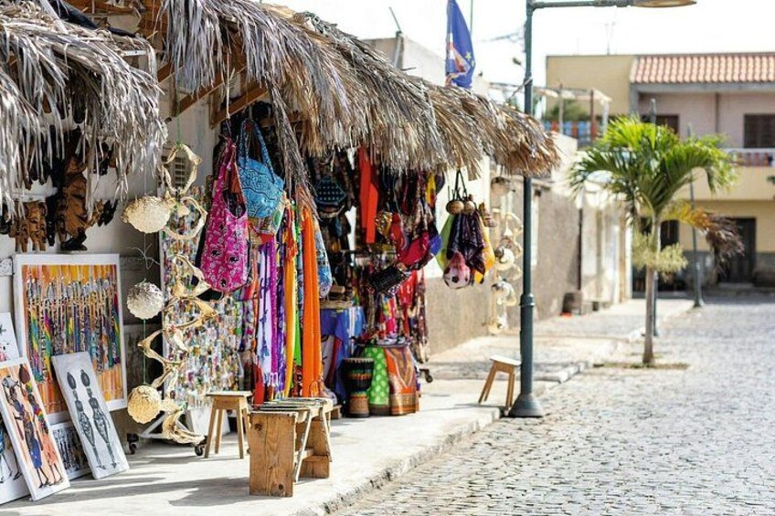 Een straatmarkt met kleurrijke tassen en accessoires, uitgestald op een houten kraam. 2