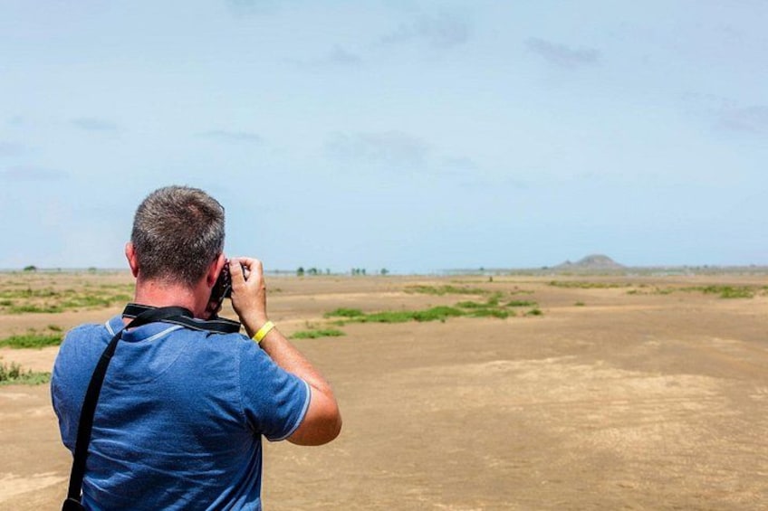 Une personne prend une photo d’un paysage, avec un ciel dégagé et des collines à l’horizon. 3