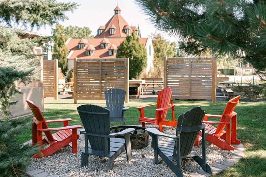 A fire pit with chairs around it, a wooden fence, and a house in the background. 5