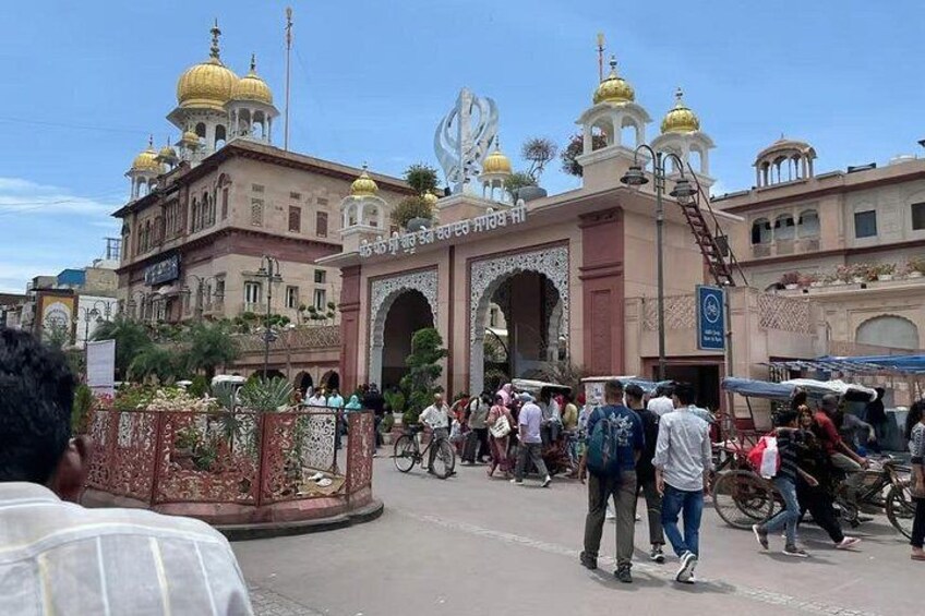 A busy street with a prominent archway and golden domes. 2