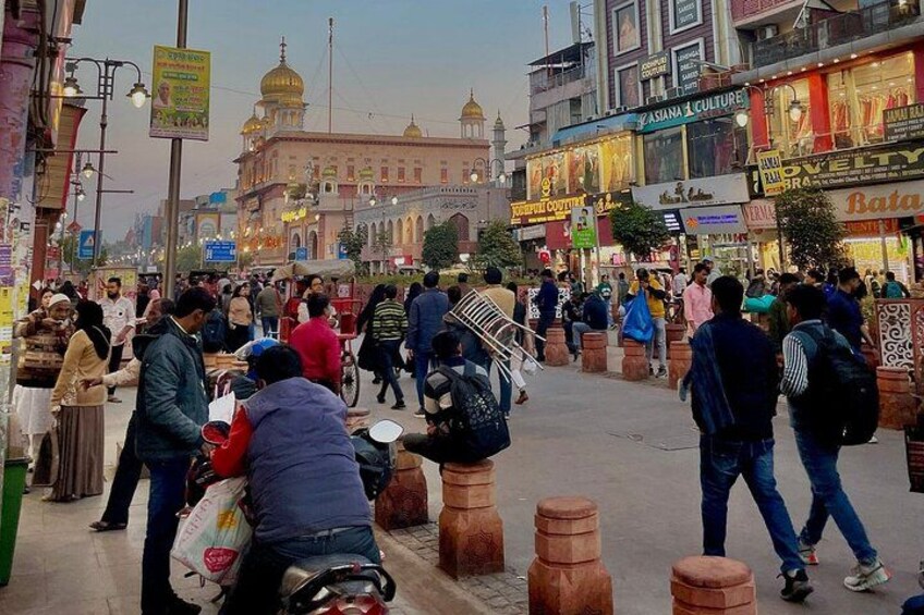 Una calle concurrida, gente caminando, tiendas y un edificio destacado con una cúpula. 5