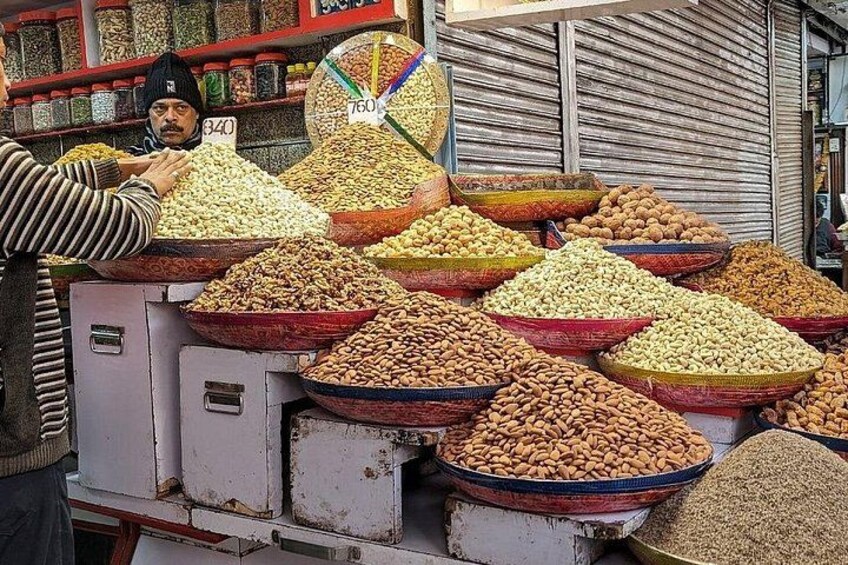 A market stall with large bowls of nuts and grains. 4