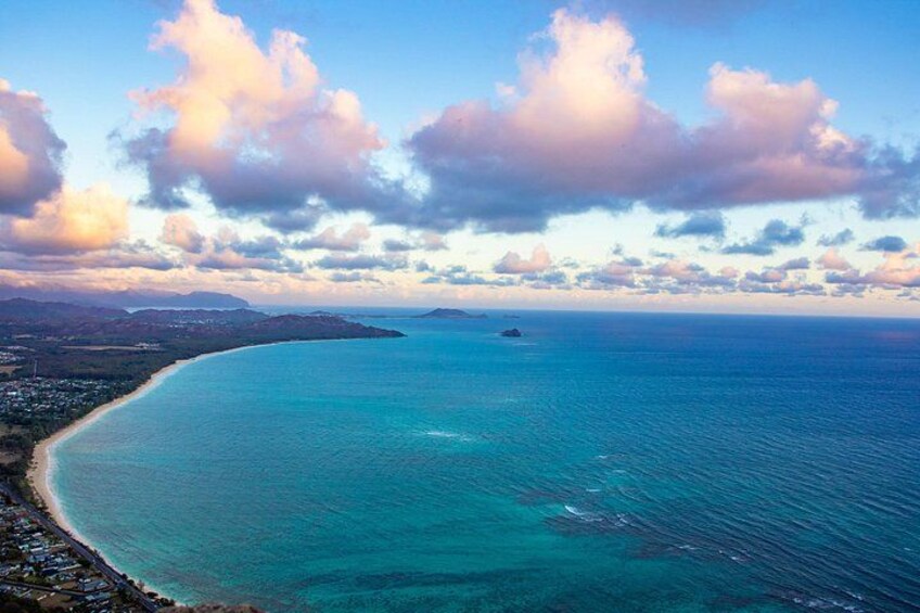Un paisaje costero con mar azul cristalino, una playa de arena y una isla en la distancia. 4