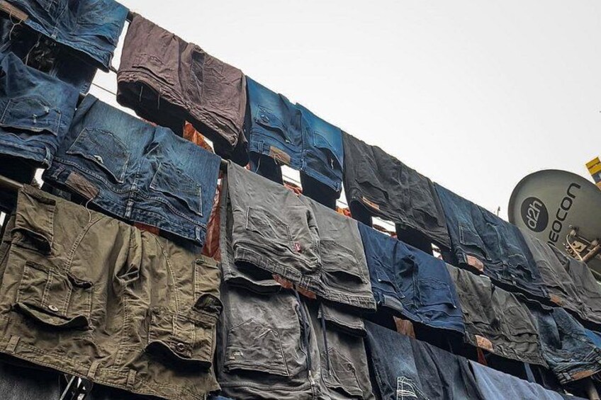 Un gruppo di jeans appesi a una corda, con un'antenna parabolica visibile sullo sfondo. 4