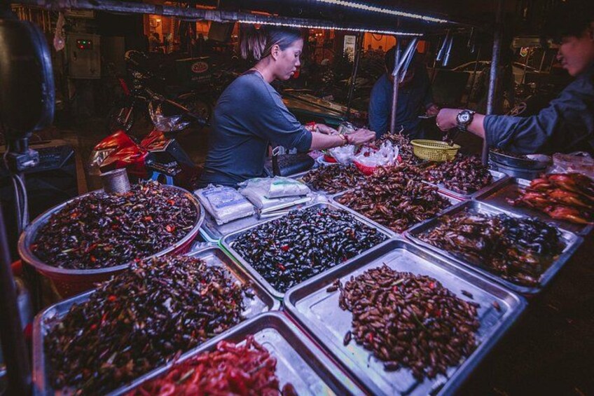 A vendor stall with various seafood displayed in trays. 5