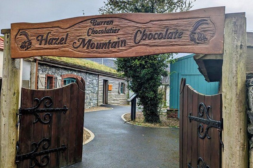 A wooden sign with 'Hazel Mountain Chocolate' written on it, leading to a gate. 2