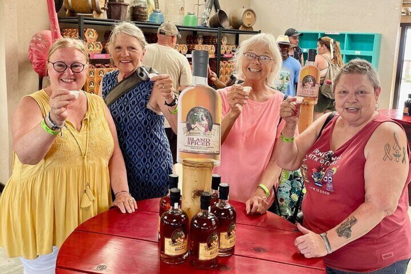 A group of people at a table with bottles of liquor and a bottle of 'Island Spice'. 4