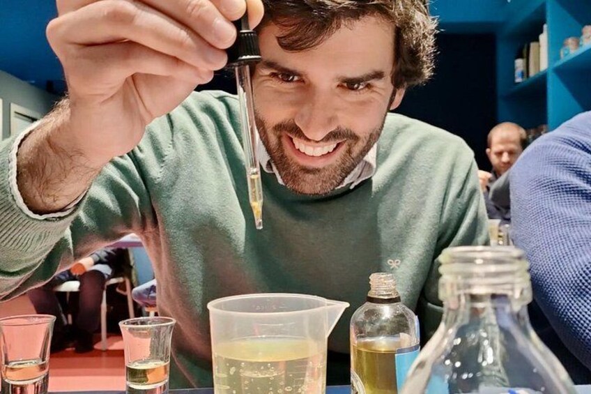 Een persoon houdt een druppelaar vast, met laboratoriumglaswerk en flessen op een tafel. 1