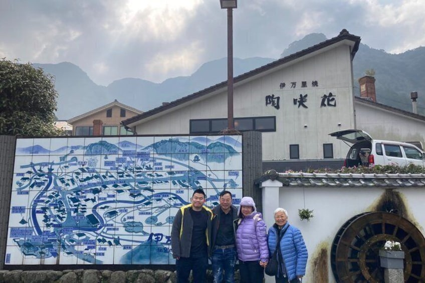 Un murale piastrellato, un edificio con un'insegna e montagne sullo sfondo. 5