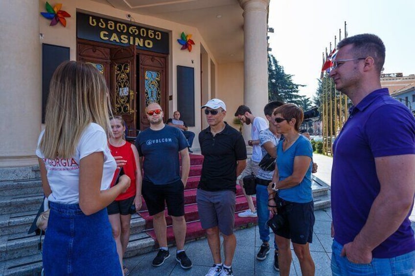 Un groupe de personnes se tient devant un bâtiment sur lequel on peut lire l’inscription « CASINO ». 4