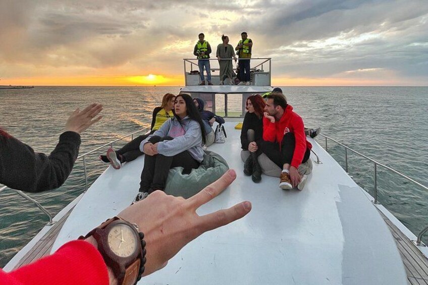 A boat with people on deck during sunset. 5