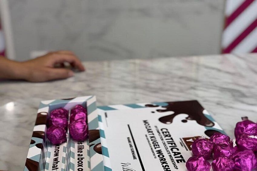 Une boîte de chocolats posée sur une surface en marbre, accompagnée d’un certificat d’authenticité. 2