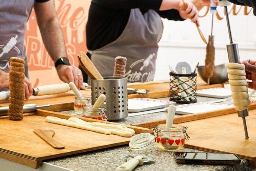 A cooking demonstration with rolling pins, wooden spoons, and a rolling pin stand. 2