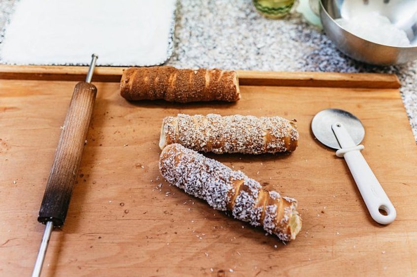 Drie gebakjes op een houten plank, een deegroller en een bakrol. 5
