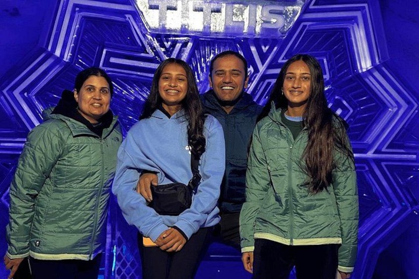 Cuatro personas de pie frente a un fondo azul con diseño geométrico, con la palabra 'TELES' a la vista. 5