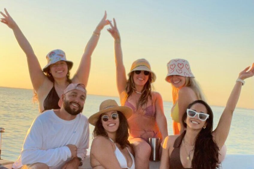 Un groupe de personnes se trouve sur un bateau au coucher du soleil. 1