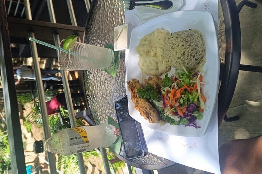 A meal with rice, salad, and a grilled item on a table outdoors. 3