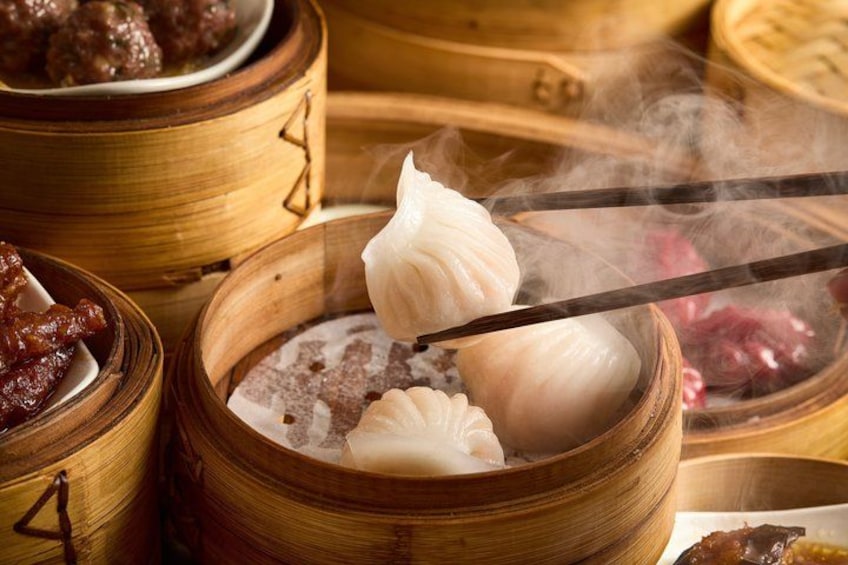 Una vaporera de bambú con dumplings y una olla humeante. 1
